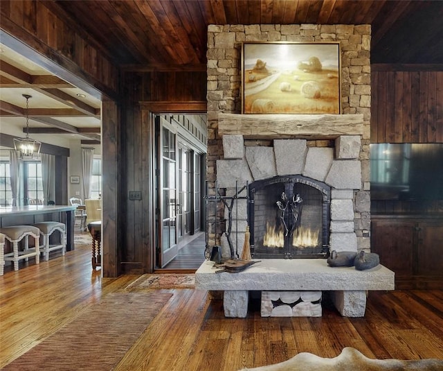 39 Firesong Ln, Glenville, NC 28736 - living room with wood walls, a wood ceiling with exposed beams, hardwood / wood-style flooring, a chandelier, and a fireplace