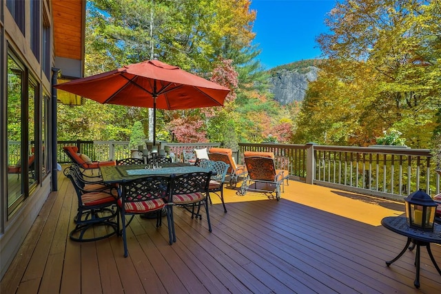 deck featuring outdoor dining space and a mountain view