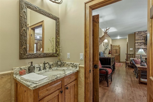 bathroom featuring vanity, wainscoting, and wood finished floors