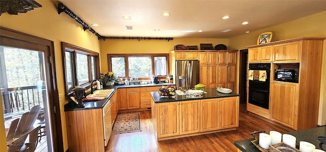 kitchen with a kitchen island, dark countertops, dark wood finished floors, black appliances, and recessed lighting