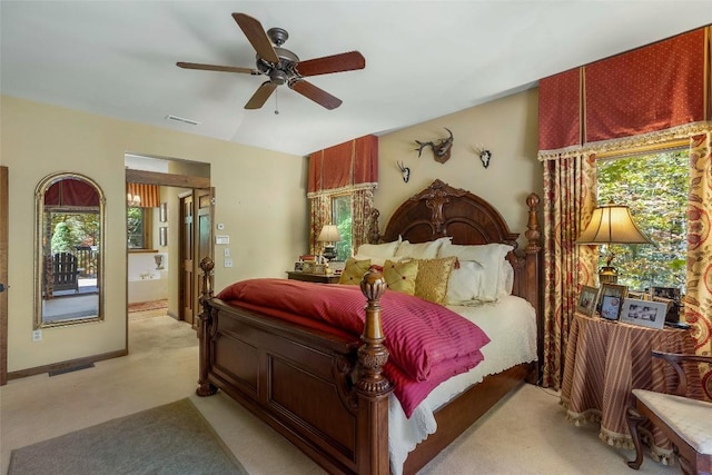 bedroom featuring a ceiling fan, visible vents, multiple windows, and light carpet