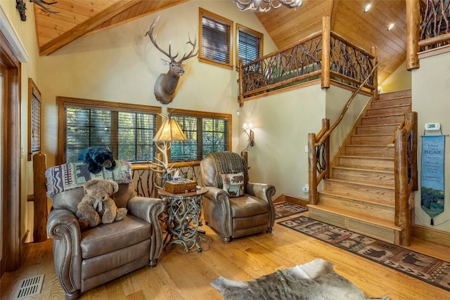 living room with high vaulted ceiling, stairs, wooden ceiling, wood finished floors, and visible vents