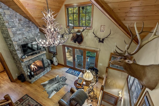 living room with an inviting chandelier, wood finished floors, a fireplace, wood ceiling, and vaulted ceiling
