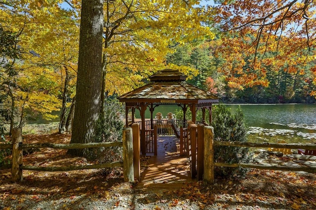 view of property's community with a gazebo, a view of trees, and a water view