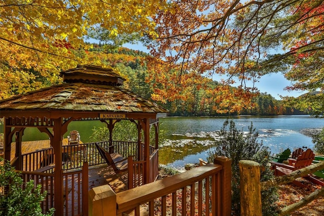 dock area featuring a gazebo, a water view, and a wooded view