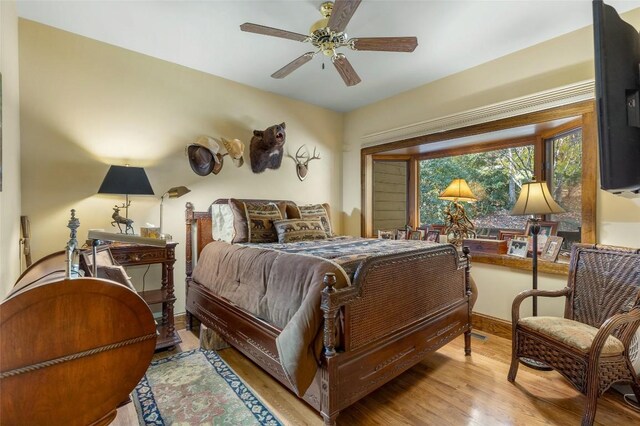 bedroom with baseboards, ceiling fan, and wood finished floors