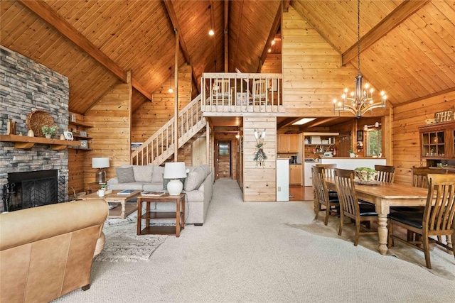 735 Trays Island Rd, Sapphire, NC 28774 - carpeted living room with wood walls, high vaulted ceiling, a fireplace, a wood ceiling with exposed beams, and a chandelier