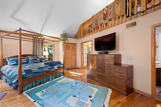 bedroom featuring high vaulted ceiling, visible vents, baseboards, and light wood finished floors