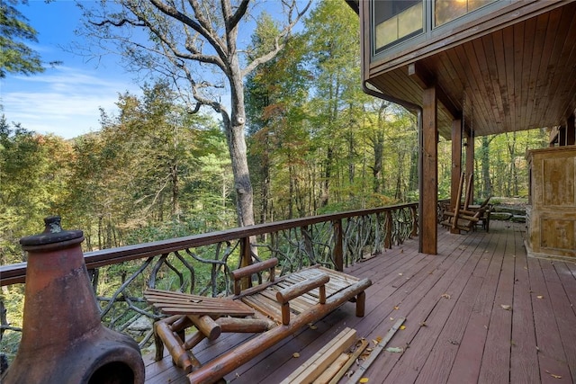 wooden terrace featuring a forest view