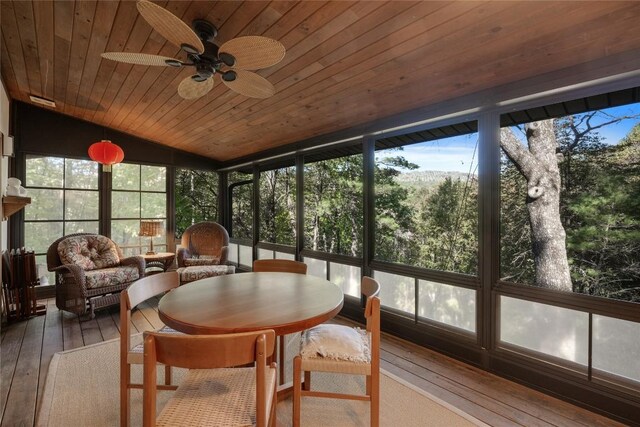 sunroom featuring wood ceiling, a wooden deck, hardwood / wood-style floors, and lofted ceiling