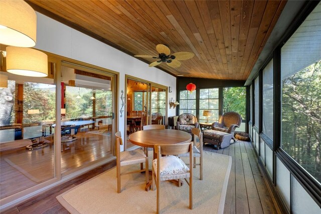 sunroom featuring vaulted ceiling, wood ceiling, a ceiling fan, and hardwood / wood-style floors