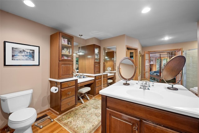 full bathroom featuring vanity, toilet, recessed lighting, baseboards, and wood finished floors