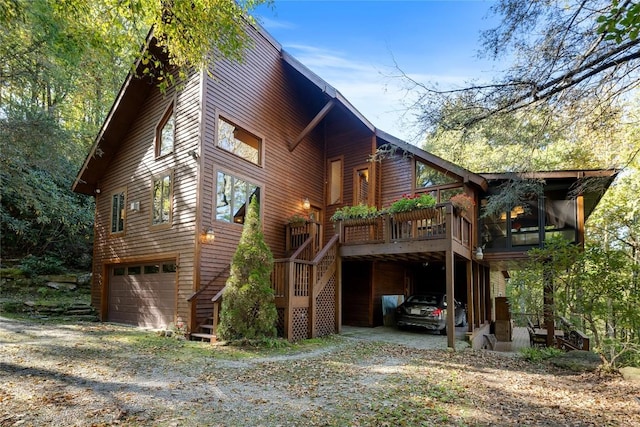 exterior space featuring an attached garage, driveway, and stairway