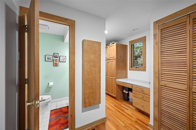 bathroom featuring toilet, baseboards, visible vents, and wood finished floors