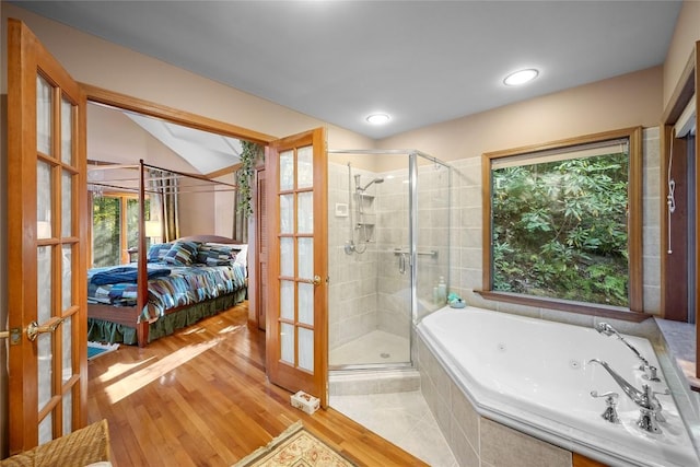 ensuite bathroom with ensuite bathroom, a shower stall, french doors, and a tub with jets