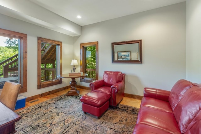 living area featuring baseboards, wood finished floors, visible vents, and recessed lighting