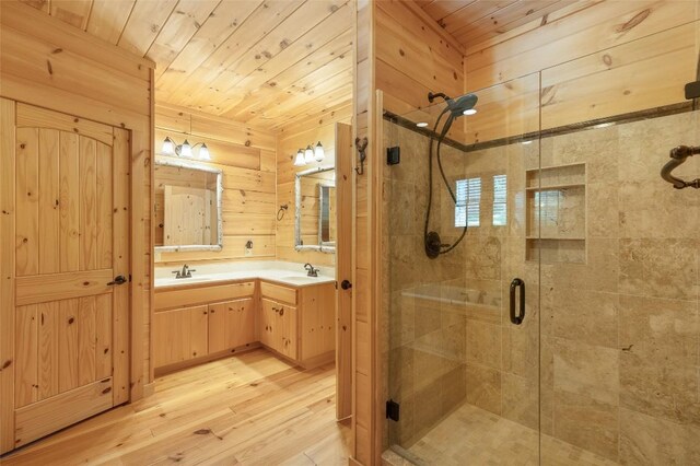 full bath featuring a shower stall, wooden walls, wood finished floors, vanity, and wooden ceiling