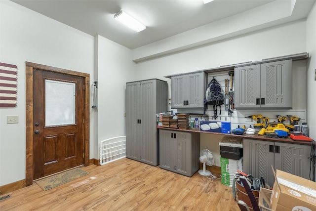 kitchen with light wood finished floors, gray cabinetry, and visible vents