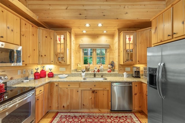 kitchen featuring light wood-style floors, wood ceiling, stainless steel appliances, and a sink