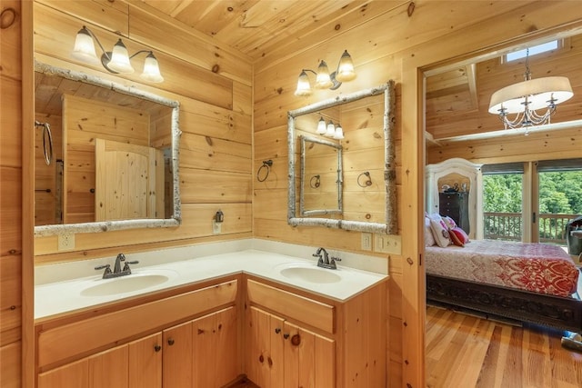 ensuite bathroom with double vanity, wood finished floors, ensuite bathroom, and a sink
