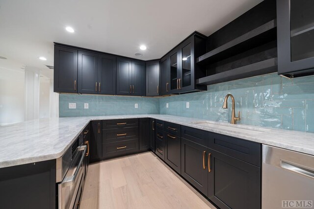 kitchen with dishwasher, light stone countertops, sink, and light hardwood / wood-style floors