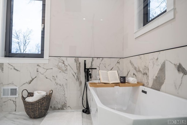 bathroom with a washtub and a wealth of natural light