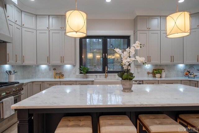 kitchen featuring a kitchen bar, high end stainless steel range, a kitchen island, and backsplash