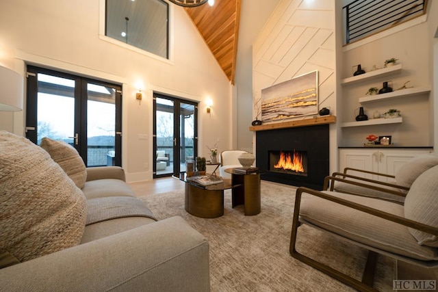 living room with wooden ceiling, a towering ceiling, built in features, and french doors