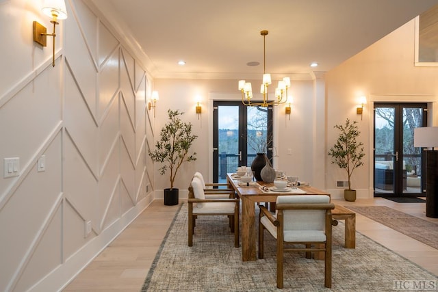 dining room with an inviting chandelier, light hardwood / wood-style floors, french doors, and a healthy amount of sunlight