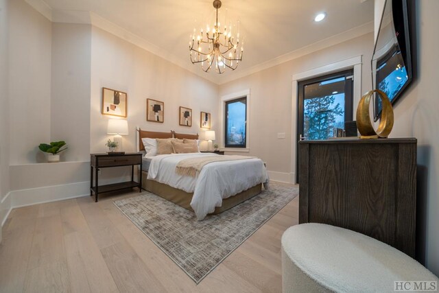 bedroom featuring ornamental molding, light hardwood / wood-style floors, and a notable chandelier