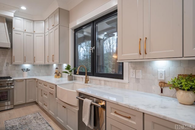 kitchen with light hardwood / wood-style flooring, sink, backsplash, stainless steel appliances, and light stone countertops