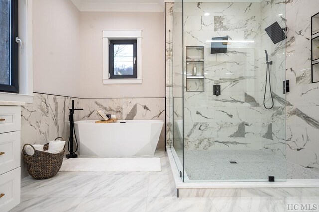 bathroom with tile walls, vanity, crown molding, and shower with separate bathtub