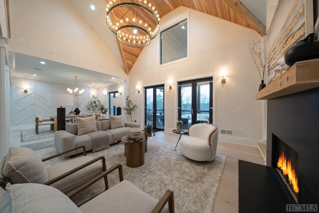 living room featuring high vaulted ceiling, a chandelier, wooden ceiling, light wood-type flooring, and french doors