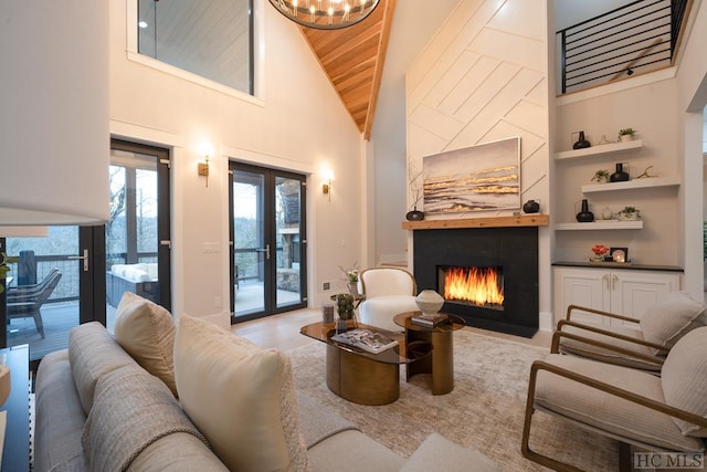 living room with wood ceiling, a high ceiling, french doors, and built in shelves