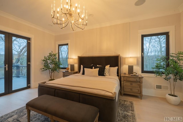 bedroom featuring multiple windows, access to exterior, light wood-type flooring, and french doors