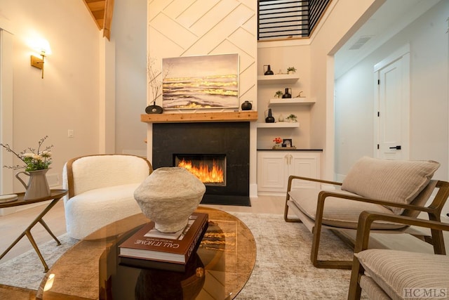 sitting room with light wood-type flooring and built in features