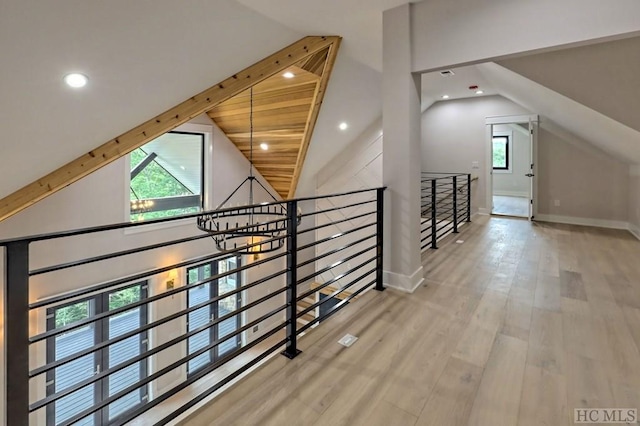 hall with lofted ceiling and hardwood / wood-style floors