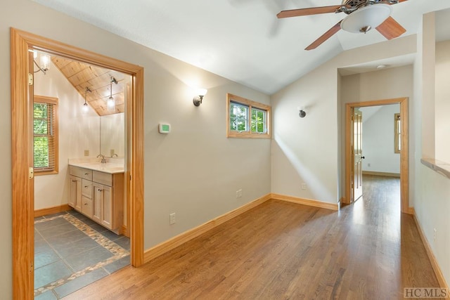 interior space with lofted ceiling, sink, hardwood / wood-style floors, and ceiling fan