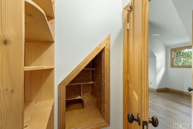 stairs featuring vaulted ceiling and hardwood / wood-style floors