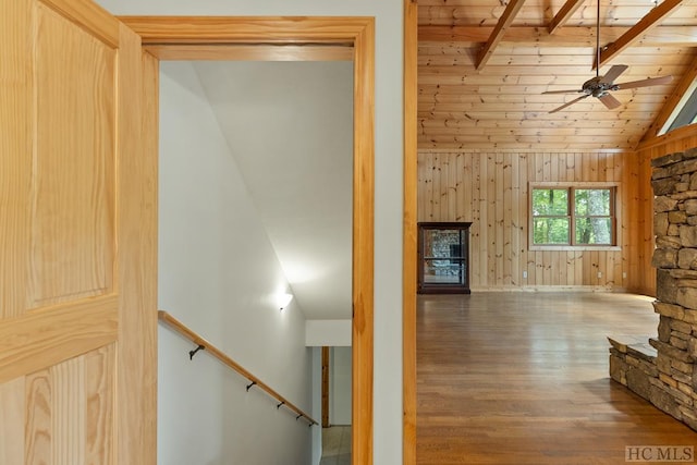 interior space featuring hardwood / wood-style floors, vaulted ceiling with beams, wood walls, wooden ceiling, and a fireplace