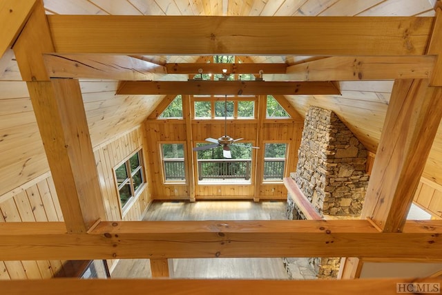 interior space with wooden ceiling, wooden walls, hardwood / wood-style floors, and vaulted ceiling with beams