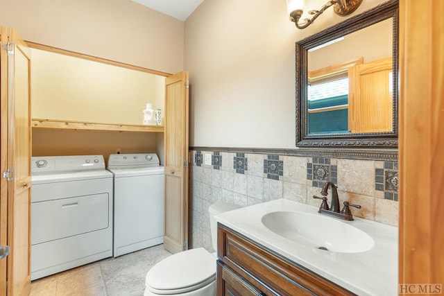 bathroom featuring tile patterned floors, vanity, toilet, and separate washer and dryer