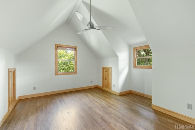 additional living space with a healthy amount of sunlight, light hardwood / wood-style flooring, ceiling fan, and lofted ceiling