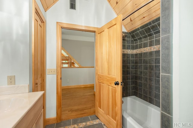 bathroom with tile patterned floors, vanity, and tiled shower / bath combo