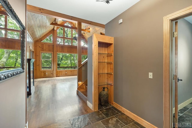 interior space with dark wood-type flooring, lofted ceiling with beams, and plenty of natural light