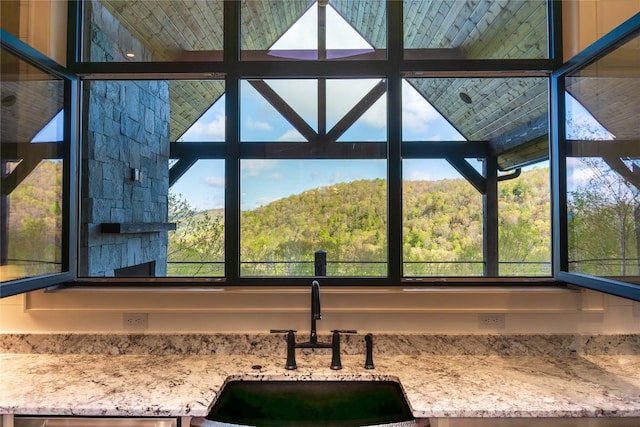 369 Firesong Ln, Glenville, NC 28736 - kitchen view of a sink, light stone counters, a wooded view, and stainless steel dishwasher