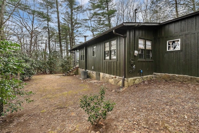 view of side of home with central AC unit and board and batten siding