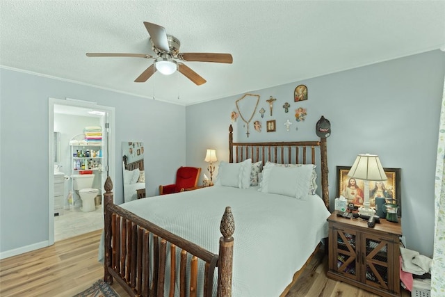 bedroom with ceiling fan, connected bathroom, light hardwood / wood-style flooring, and a textured ceiling