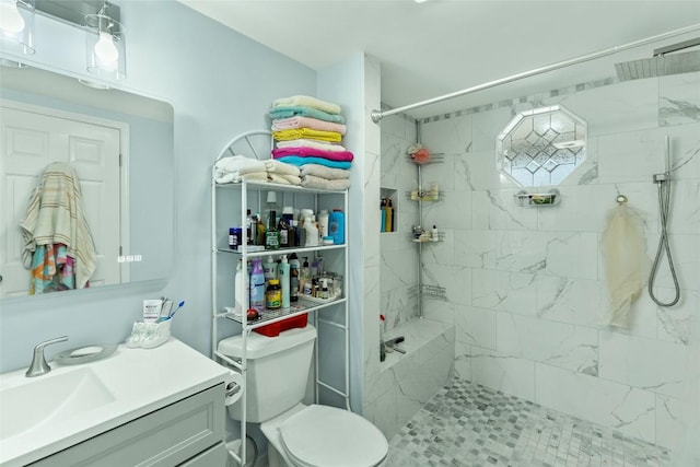 bathroom with vanity, toilet, and a tile shower