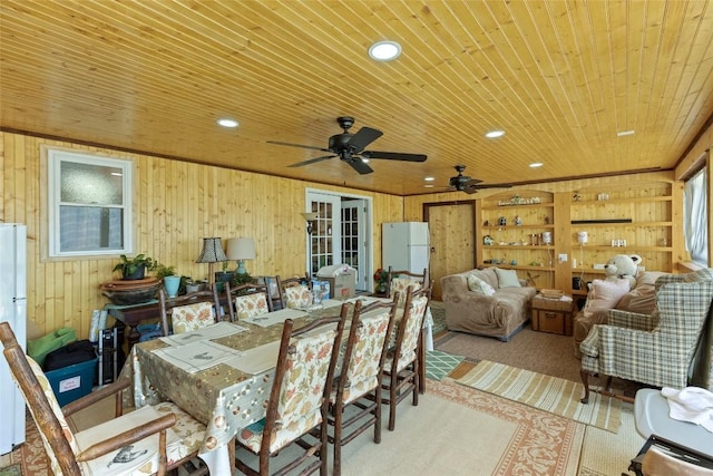 dining space with wood ceiling and wooden walls